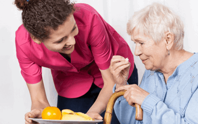 The Direct Support Professional is assisting her client by helping her with her meal.